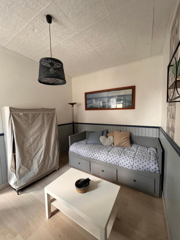 - une petite chambre avec un lit et une table dans l'établissement QUAT, à Fécamp