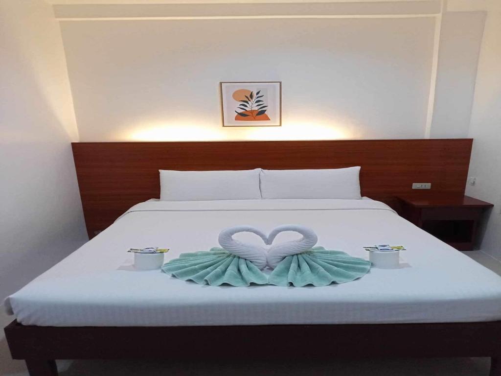 een bed met een hartdecoratie erop met twee kaarsen bij Zosimo's Inn in Siquijor