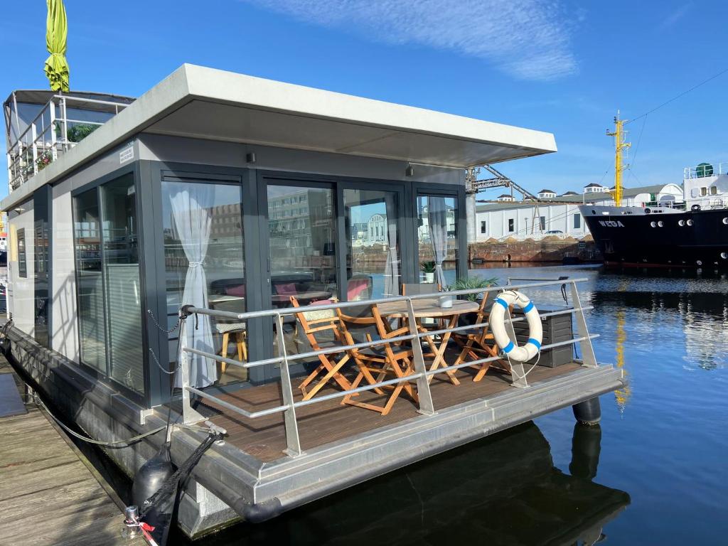 a small house on a boat in the water at Hausboot Lobster Bremerhaven in Bremerhaven