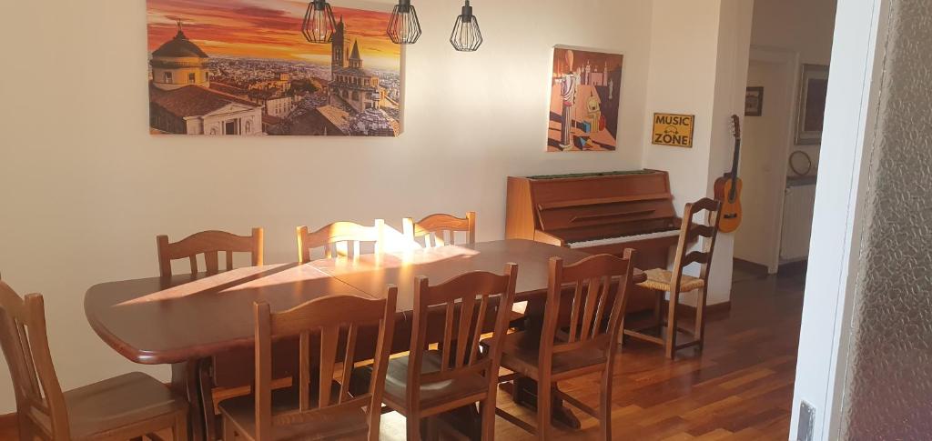 une salle à manger avec une table et un piano dans l'établissement Ice Alley Home Città Alta, à Bergame