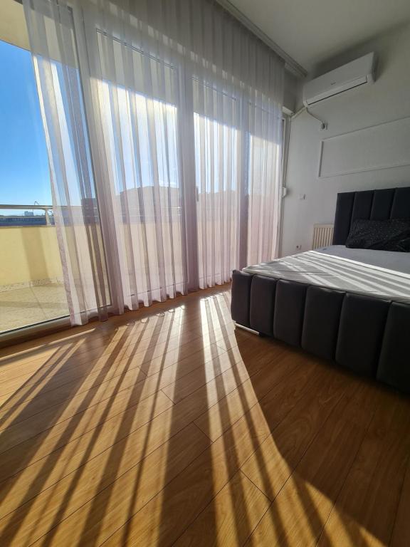 a bedroom with a bed and a large window at Apartment 2 Plisi Gjilan in Gnjilane