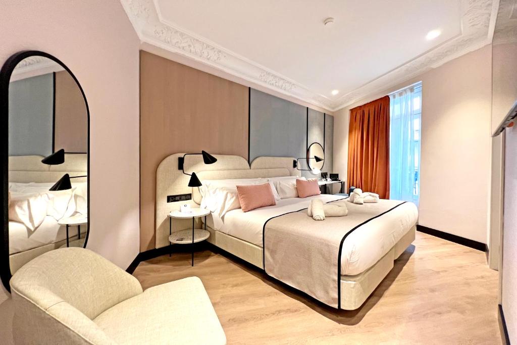 a bedroom with a large bed and a chair at Soho Boutique Turia in Valencia