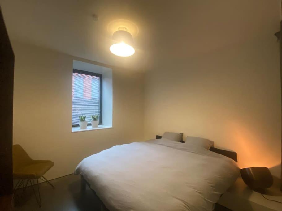 sypialnia z białym łóżkiem i oknem w obiekcie Woning Oostende - Oosteroever NIEUW w Ostendzie
