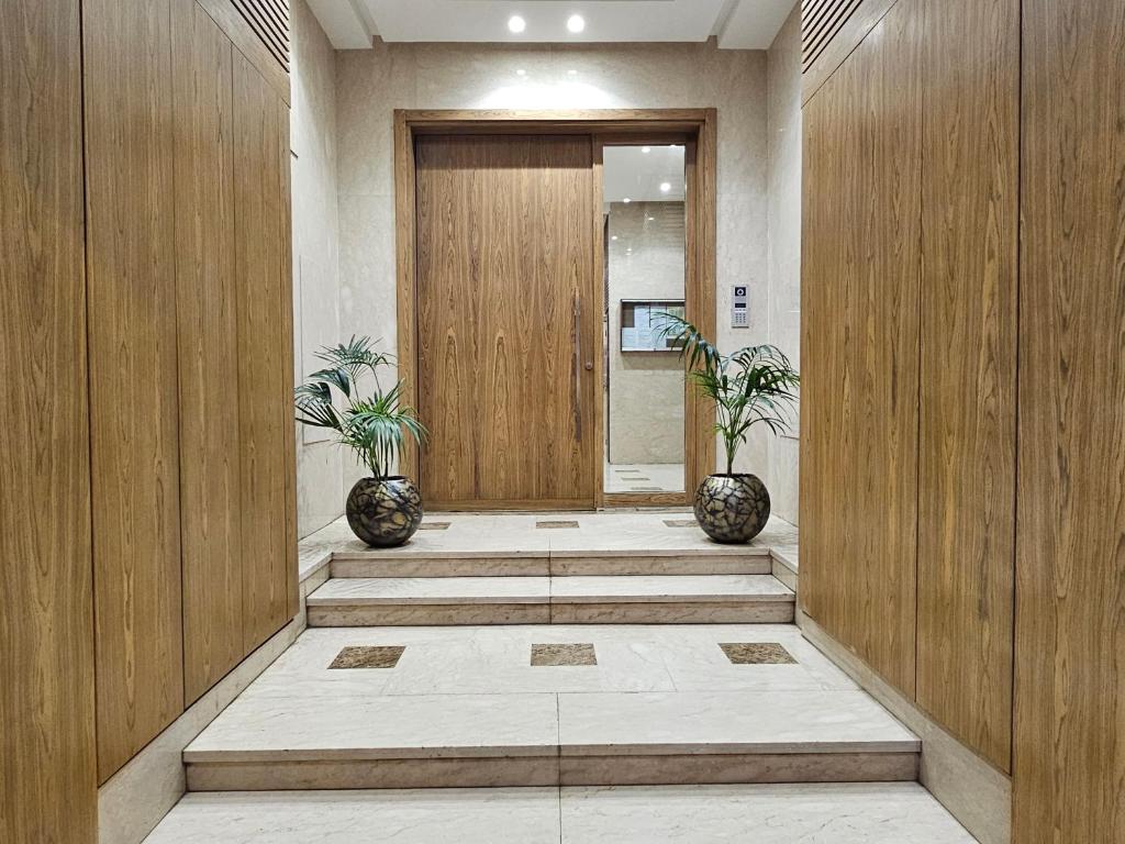 un corridoio con due piante in vaso davanti a una porta di Luxury Living 3 Bedroom Apartment with Beautiful Balcony Space, Casablanca a Casablanca