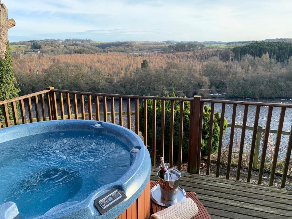a jacuzzi tub on a deck with a view at Horsey Reach Lodge in Stanley