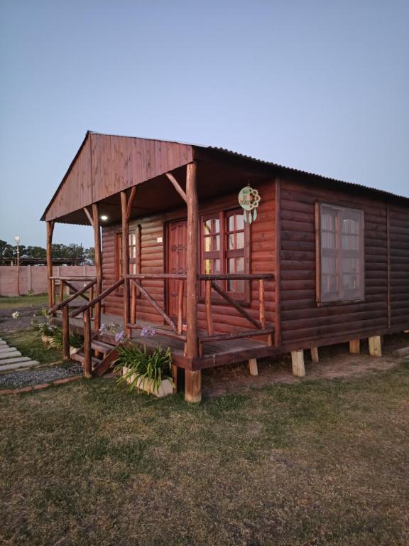 a log cabin with a thatched roof at Cabañas Las Escondidas in Chascomús