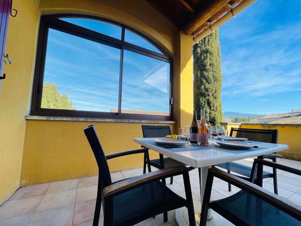 卡龐特拉的住宿－Gîte Les Vignes，阳台配有桌椅和窗户