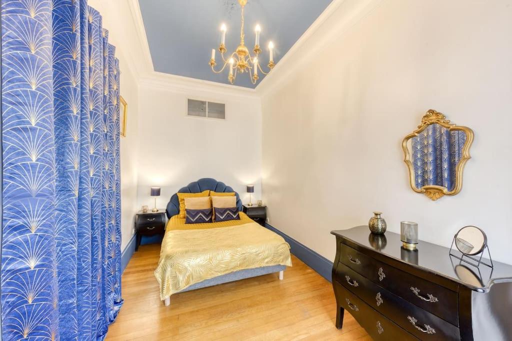 een slaapkamer met een bed met een blauw en wit gordijn bij « La cour royale » appartement prestigieux à 50m du château de Versailles in Versailles