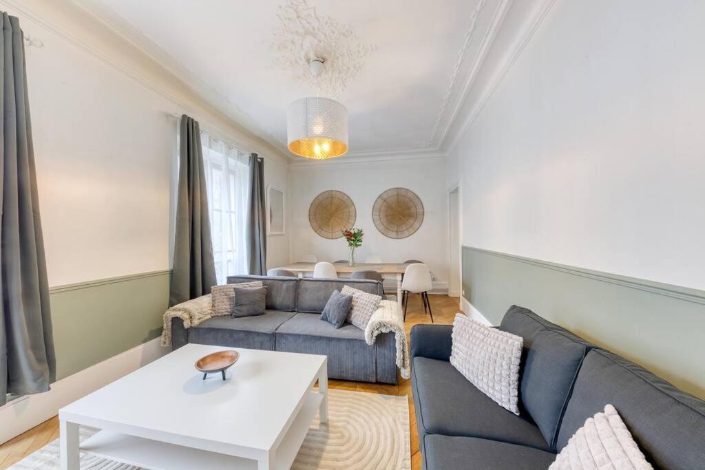 un salon avec un canapé et une table dans l'établissement « La cour royale » appartement prestigieux à 50m du château de Versailles, à Versailles