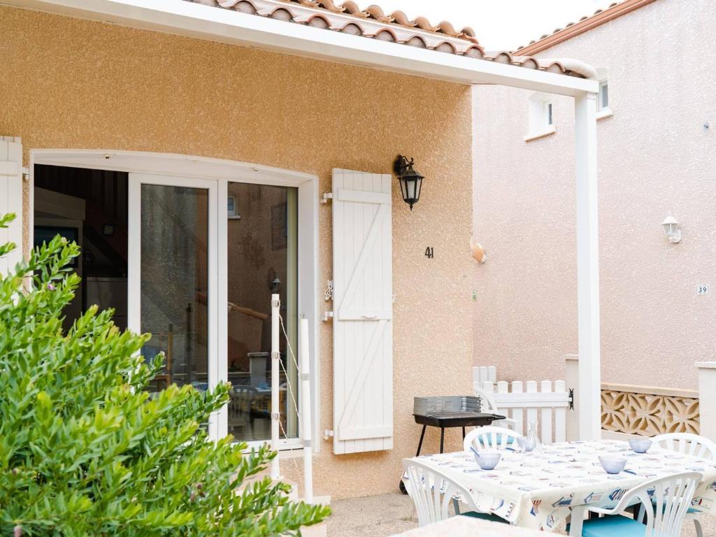 un patio avec une table et des chaises devant une maison dans l'établissement Villa cosy avec terrasse et 2 chambres - 5 pers. max à Saint Pierre La Mer, proche plage - FR-1-409-7, à Saint Pierre La Mer