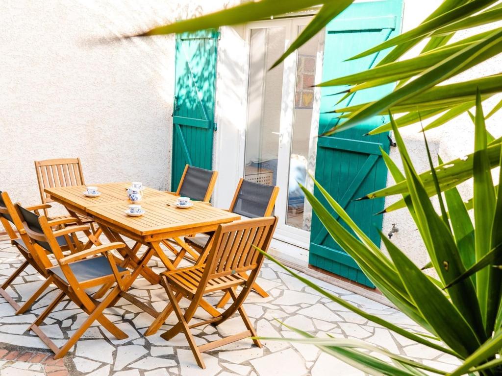 une table et des chaises en bois sur une terrasse dans l'établissement Villa 4 pièces lumineuse avec terrasse, garage, 6 couchages, proche plage et commerces, Narbonne-Plage - FR-1-409-19, à Narbonne