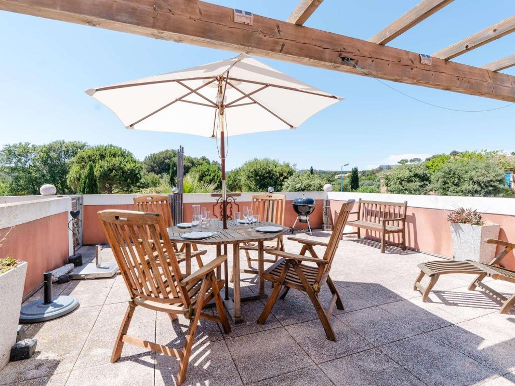 a table and chairs with an umbrella on a patio at Appartement T3 avec terrasse, parking, lave-vaisselle à Narbonne-Plage - FR-1-409-104 in Narbonne-Plage