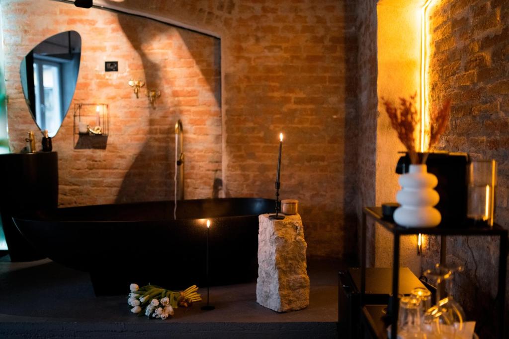 a bathroom with a black tub and a mirror at World Studio Sibiu in Sibiu