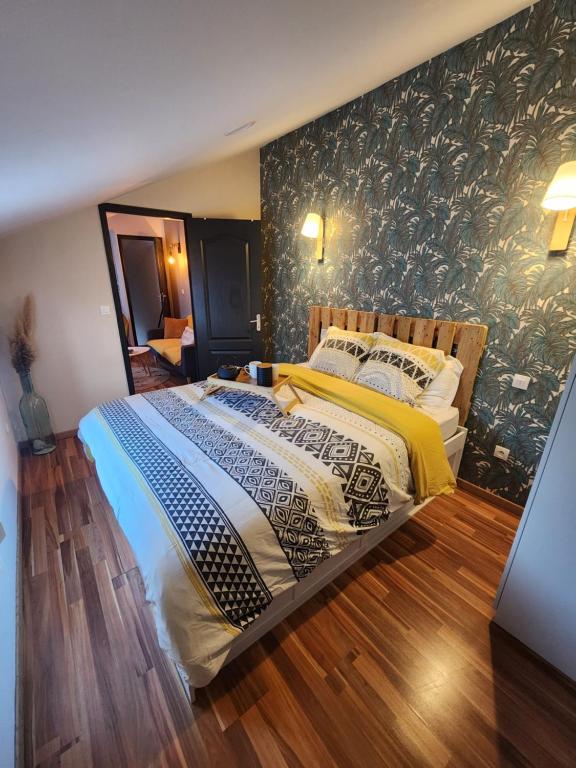 a bedroom with a large bed with a wall mural at Champétillant in Épernay