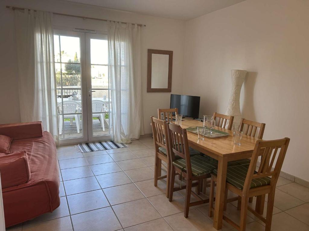 une salle à manger avec une table, des chaises et un canapé dans l'établissement Charmant duplex climatisé 3 pièces avec jardinet et garage privé - 6 couchages, Aigues-Mortes - FR-1-250-177, à Aigues-Mortes