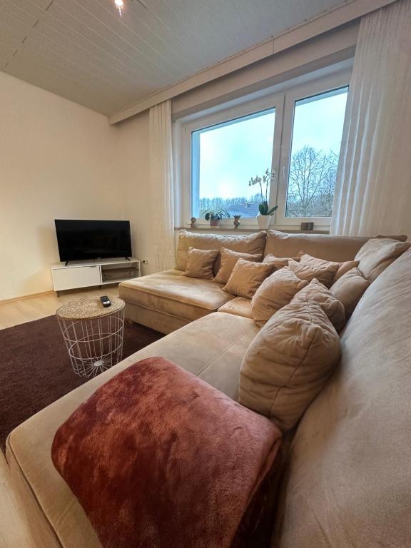 ein Wohnzimmer mit einem großen Sofa und einem TV in der Unterkunft Gemütliches Appartement - WBS in Goldkronach