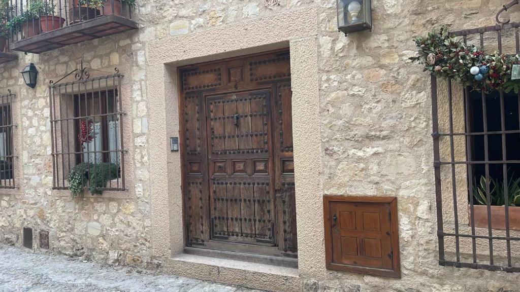 un edificio de piedra con una gran puerta de madera en Las Tongueras, en Pedraza-Segovia