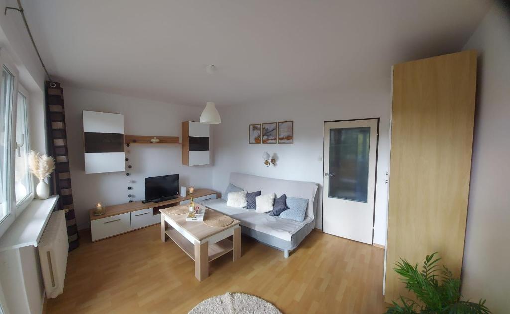 een woonkamer met een bank en een tafel bij Apartament Kolberga II in Sopot