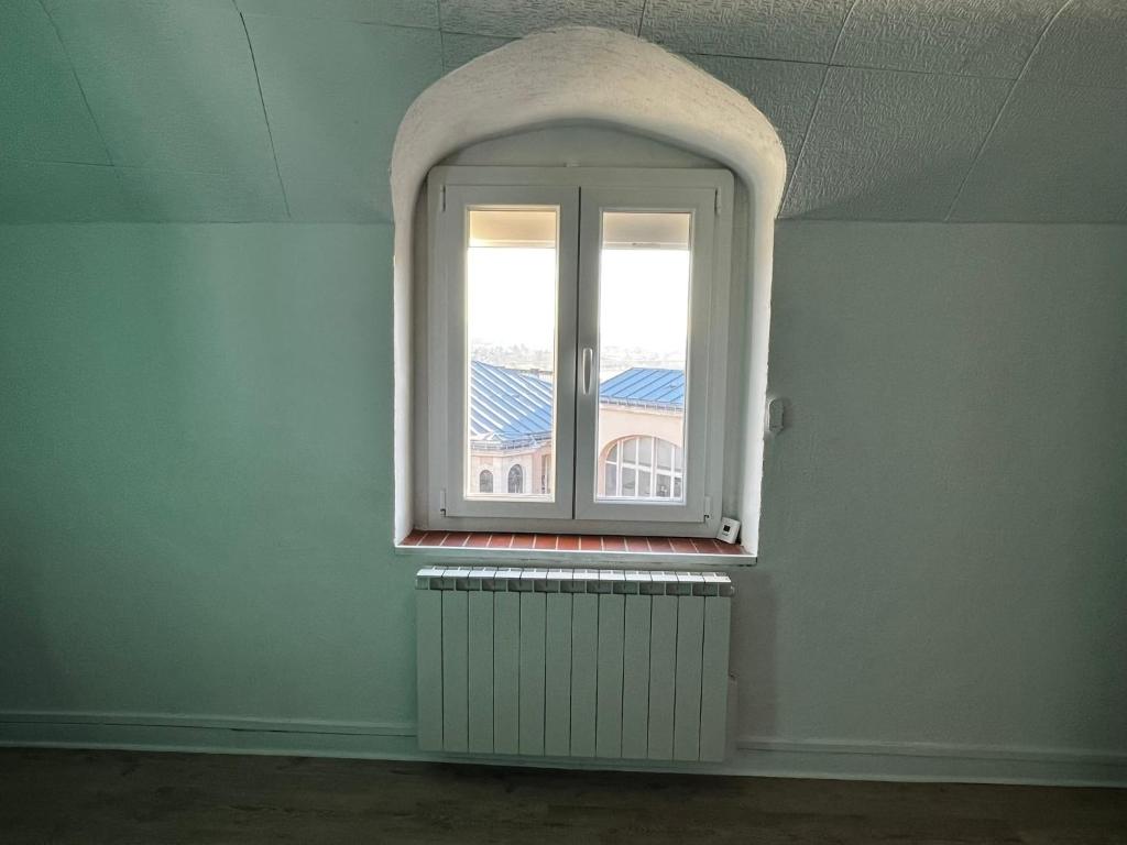 une pièce vide avec une fenêtre et un radiateur dans l'établissement T2 proche du château de Blois, à Blois