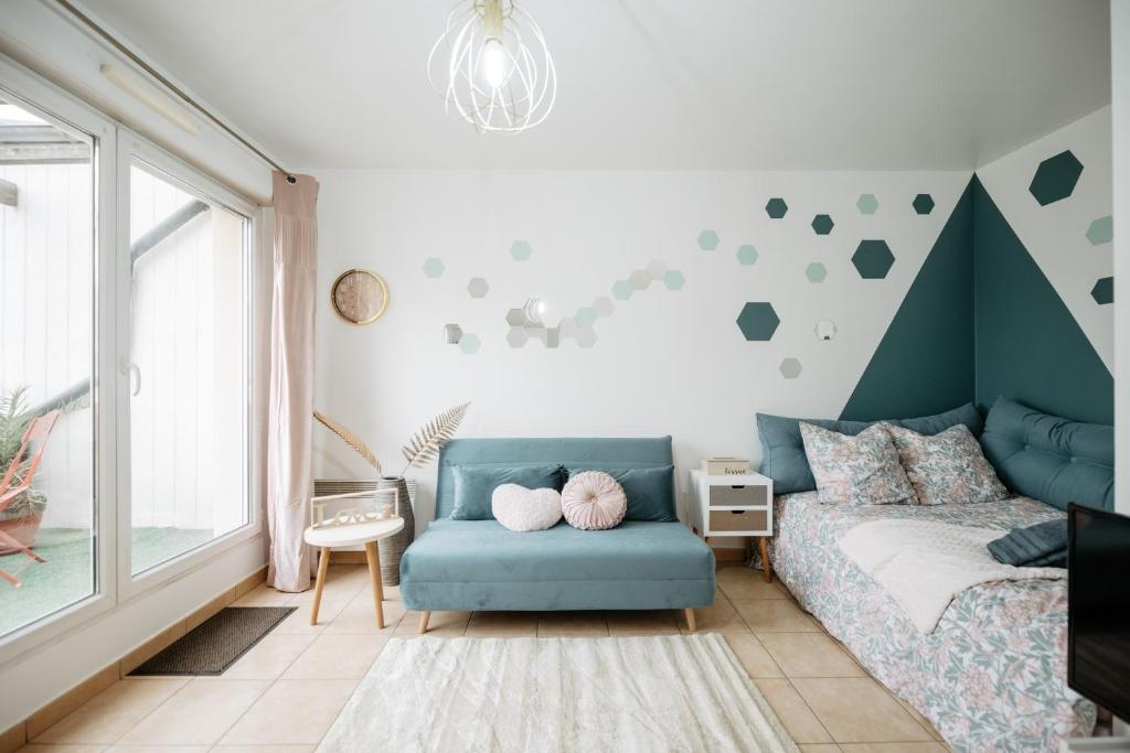 ein Schlafzimmer mit einem Bett und einem blauen Sofa in der Unterkunft Hexa Dream in Montévrain