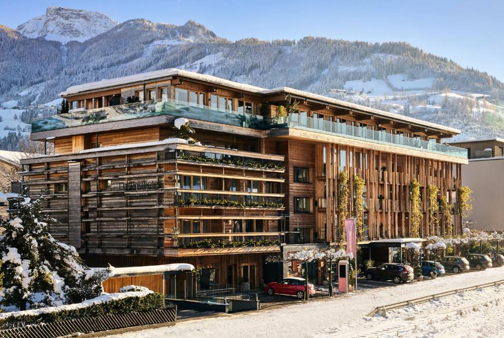 un gran edificio en una calle con una montaña en Small Luxury Hotel of the World - DasPosthotel, en Zell am Ziller
