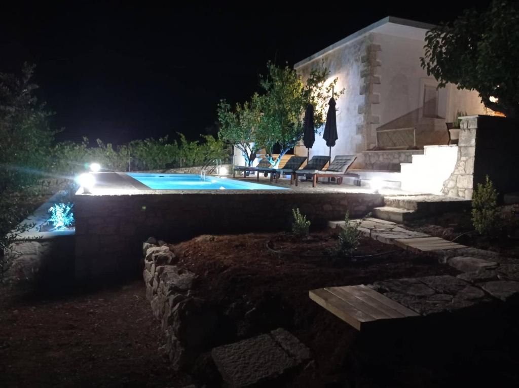 un patio trasero por la noche con piscina en PALACE Mountain view en Megála Khoráfia