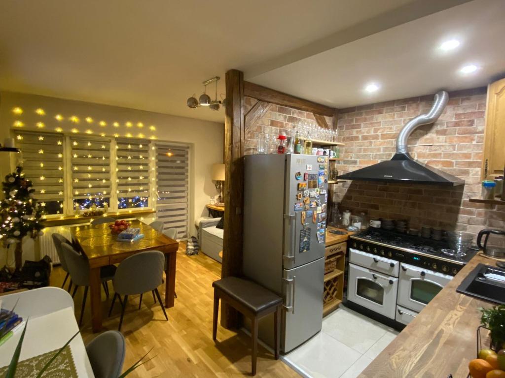 a kitchen with a stainless steel refrigerator and a table at Apartament Centrum Nowa Ruda in Nowa Ruda