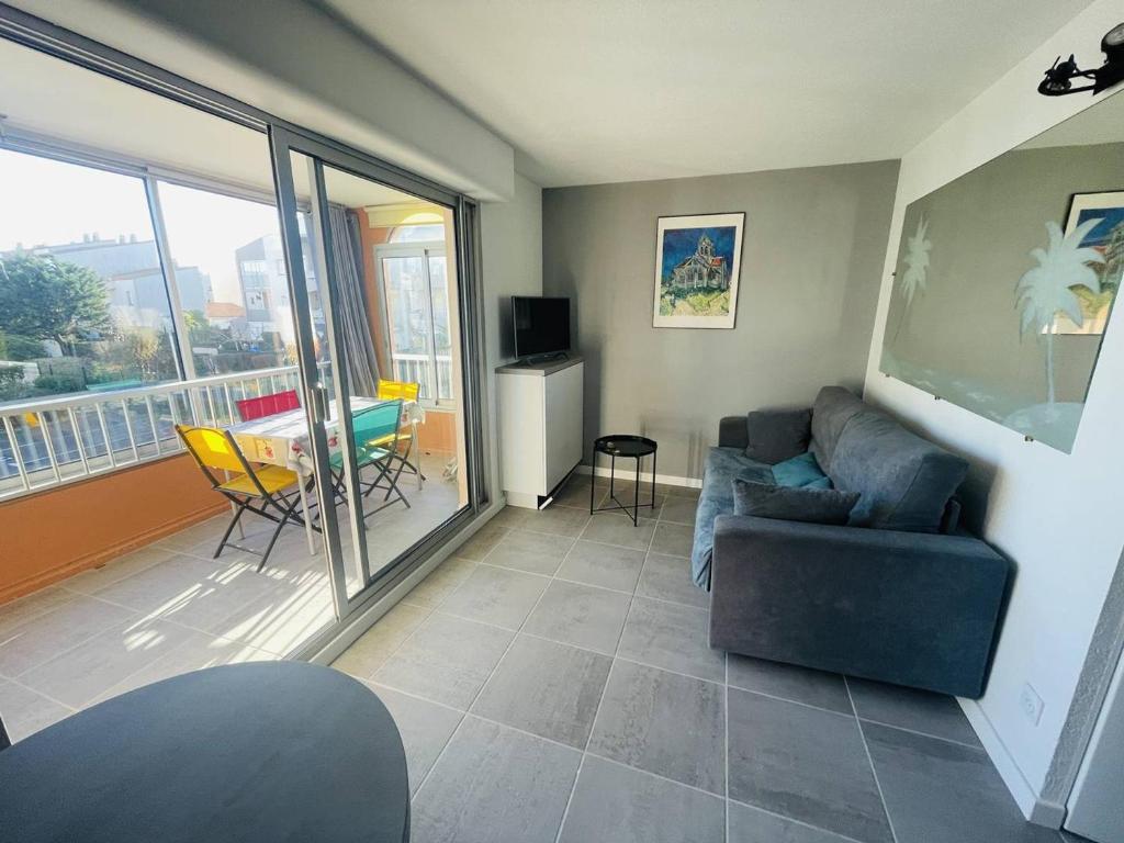 un salon avec un canapé et une table dans l'établissement Appartement rénové près de la plage Richelieu avec piscine, garage et vélos fournis - FR-1-723-113, au Cap d'Agde