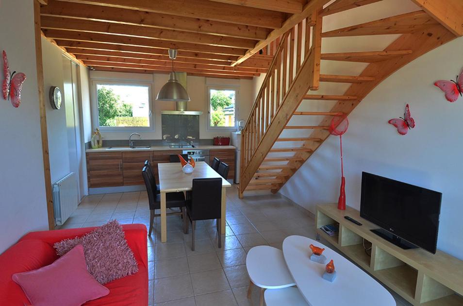 a living room with a red couch and a kitchen at Roche Blanche 1 in Saint-Lunaire