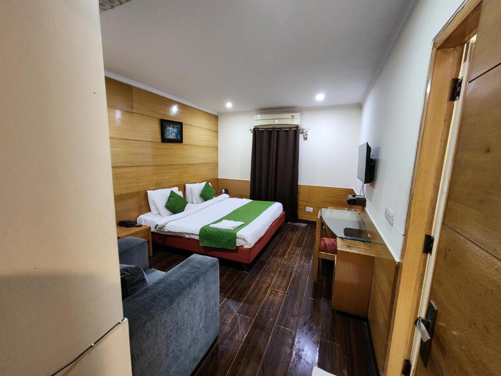 une chambre d'hôtel avec un lit et un canapé dans l'établissement Daffodils inn, à New Delhi