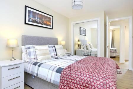 1 dormitorio con 1 cama con manta roja y blanca en Edinburgh Apartment near University of Edinburgh - Elforma, en Edimburgo