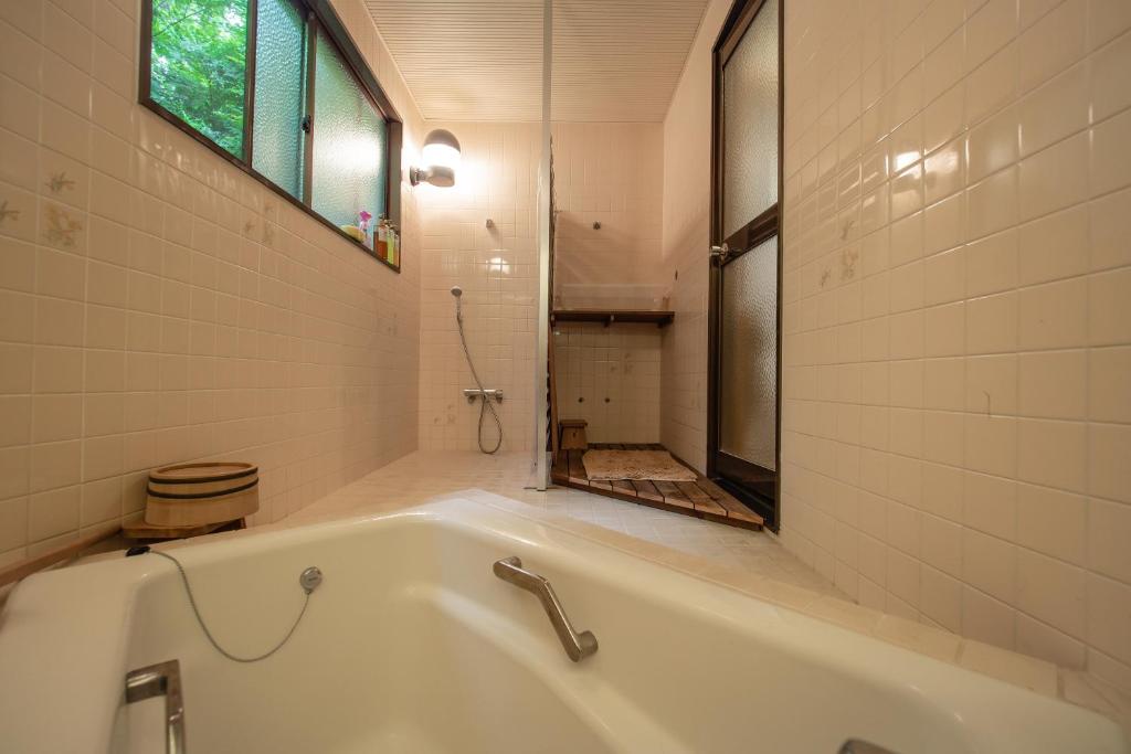 una vasca bianca in un bagno con finestra di 『箱根登山線』駅徒歩圏内※Bus stop徒歩1分※大勢で遊びたい & 癒されたい a Gora
