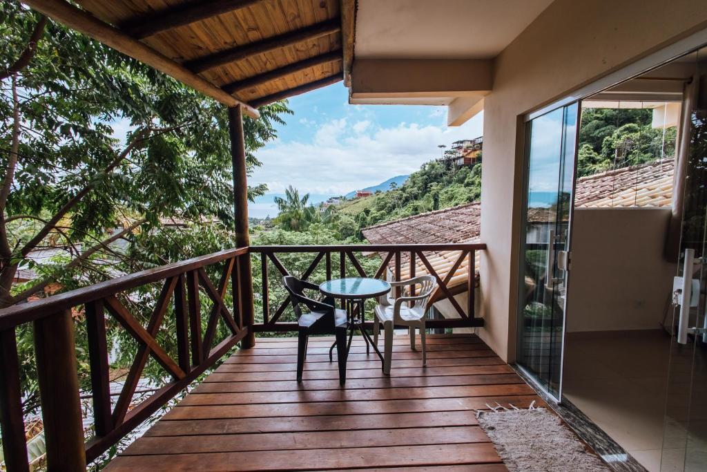 einen Balkon eines Hauses mit einem Tisch und Stühlen in der Unterkunft Chales do Ademir in Ilhabela