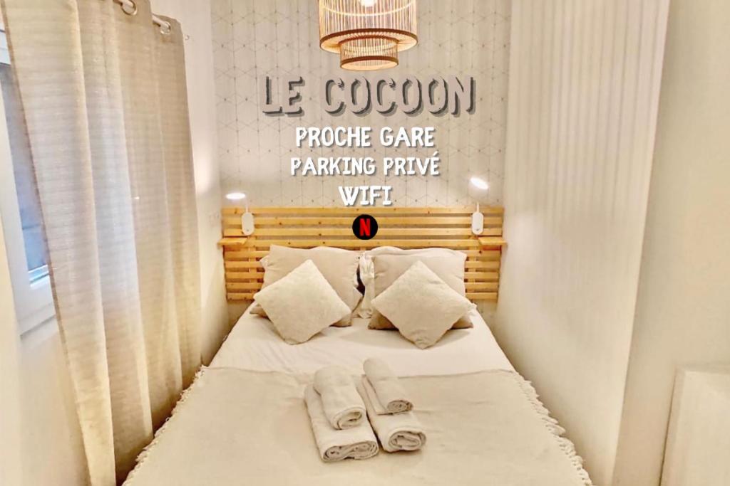 - une chambre avec un lit et des serviettes dans l'établissement LE COCOON / PROCHE GARE / NETFLIX, à Sens