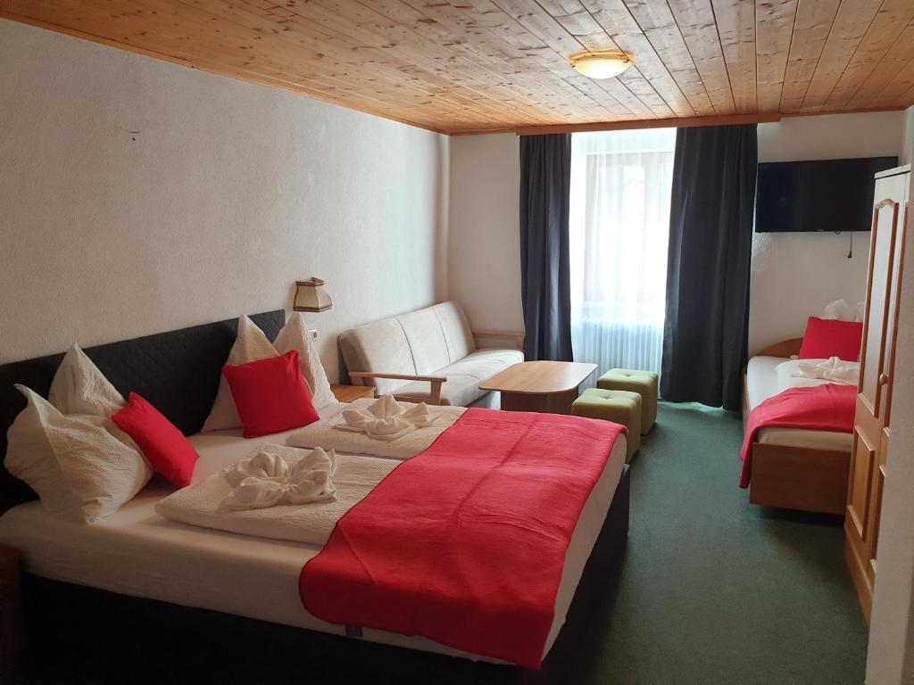 a hotel room with a bed with a red blanket at Weisses Rössel-Cavallo Bianco in Werfen