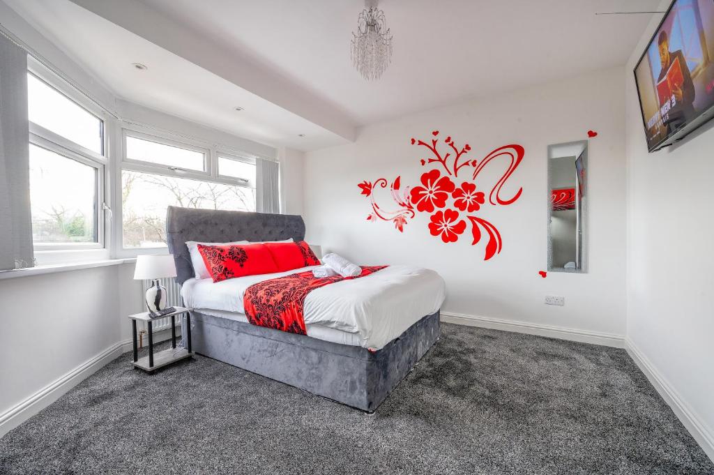 a bedroom with a bed with a red flower on the wall at *RA75L* For your most relaxed & Cosy stay + Free Parking + Free Fast WiFi * in Hunslet