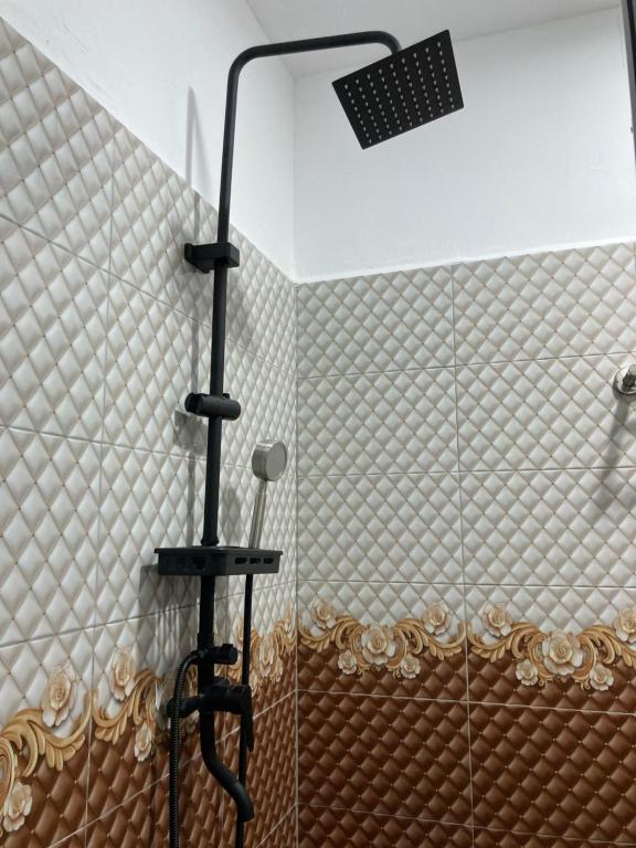 a shower with a shower head in a bathroom at Rods Homestay - Kg Agong Penaga in Kepala Batas