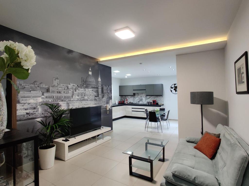 een woonkamer met een bank en een keuken bij DePiro Point Deluxe - Sliema Holiday Rental in Sliema