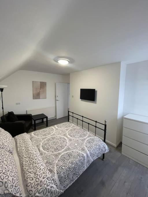 a bedroom with a bed and a tv on the wall at Opal - Executive London Flat in South Norwood