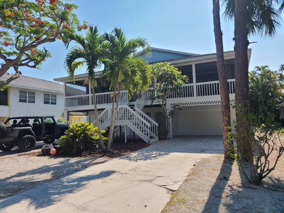 a truck parked in front of a house with palm trees at Redfish - Updated & Roomy 1.5 Mi to Beach Full Kitchen W&D in Bonita Springs