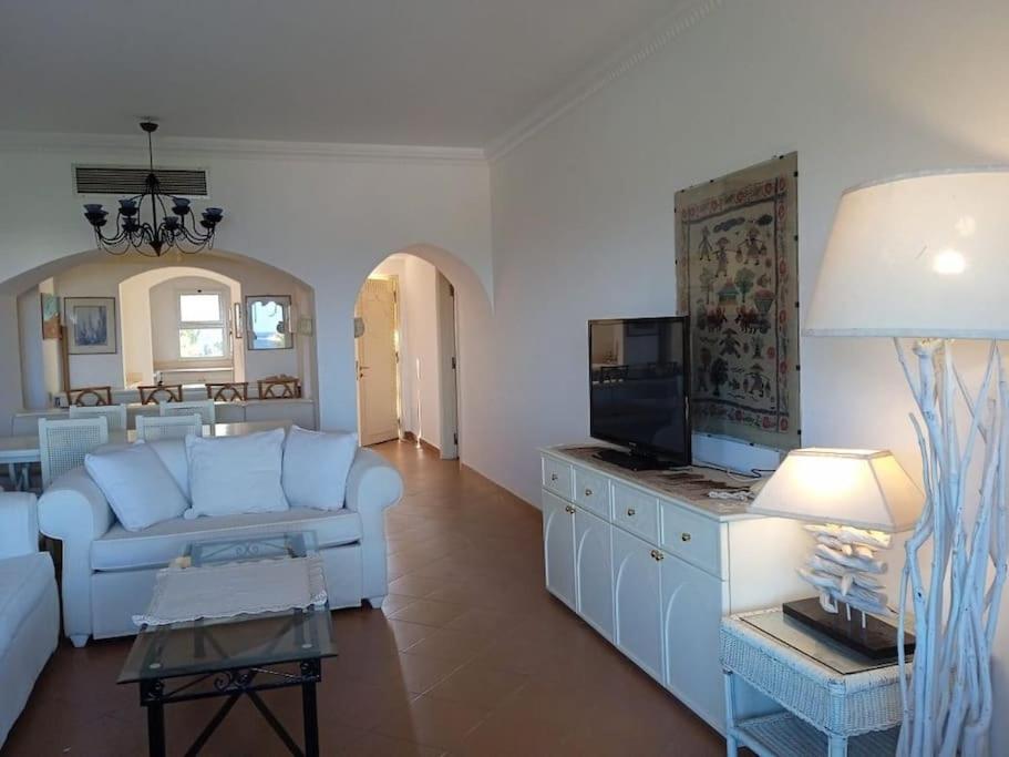a living room with a white couch and a tv at Villa bianca sul mar rosso R23124 appartamento luxury Domina in Sharm El Sheikh