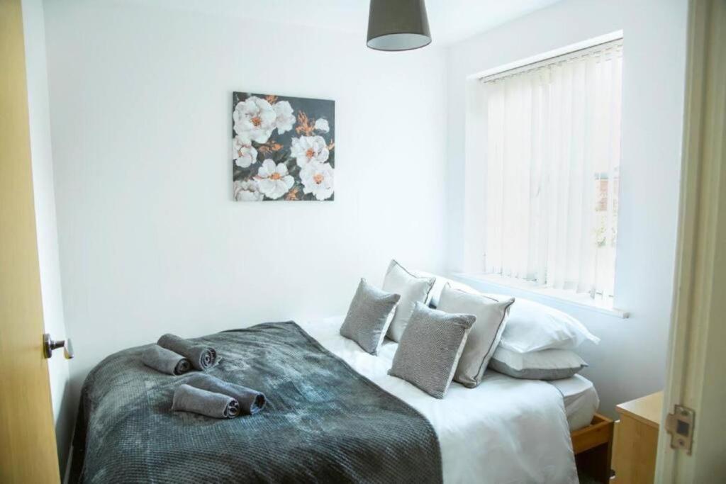 a bedroom with a bed with pillows and a window at Cosy 2-Bedroom Flat in Warrington in Warrington