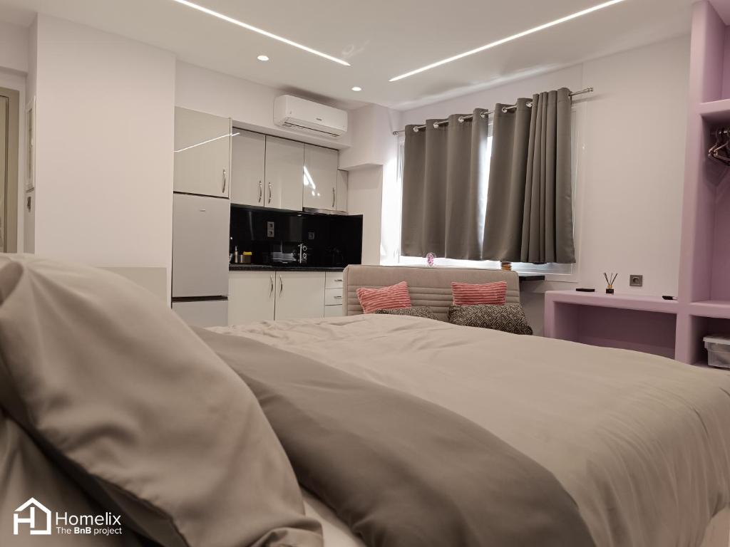 a bedroom with a large bed and a living room at Modern studio in the city center in Chalkida