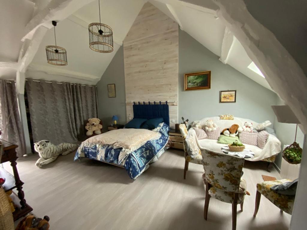 une chambre avec un lit, une table et des chaises dans l'établissement La Patriaie. chez Jacky et Maryse., à Sainte-Maure-de-Touraine