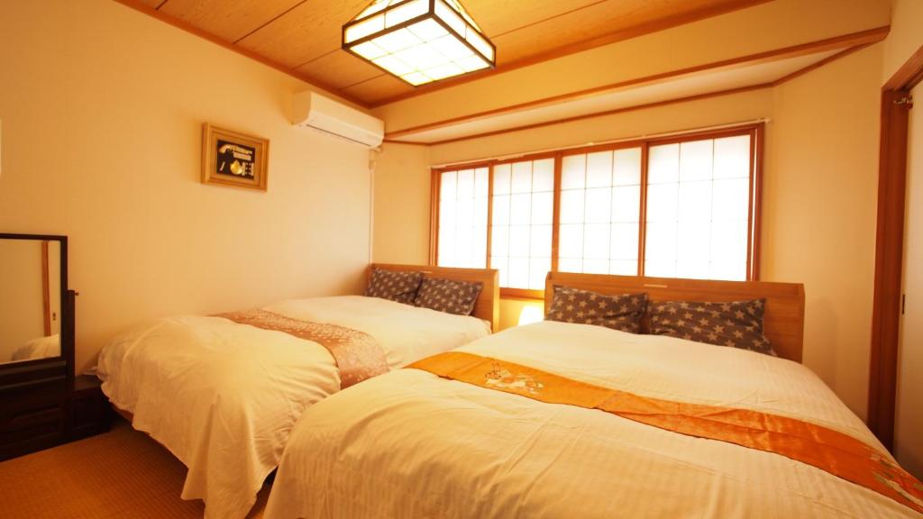 Postel nebo postele na pokoji v ubytování お湯掛け流し『草津温泉湯畑』徒歩圏内※温泉街を大勢で遊びたい & 癒されたい