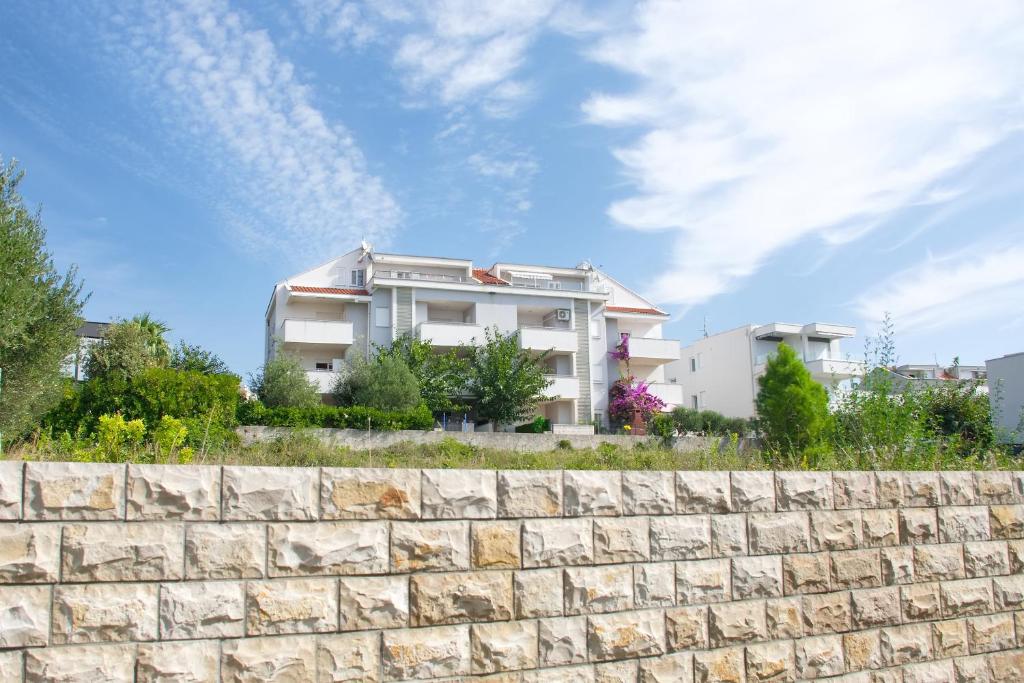 a building behind a stone wall in front of a building at Apartment MiraMar in Novalja