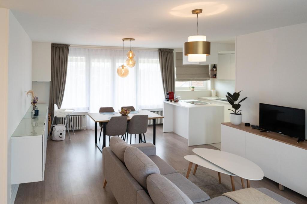 a living room and kitchen with a couch and a table at Heights of Kortrijk in Kortrijk