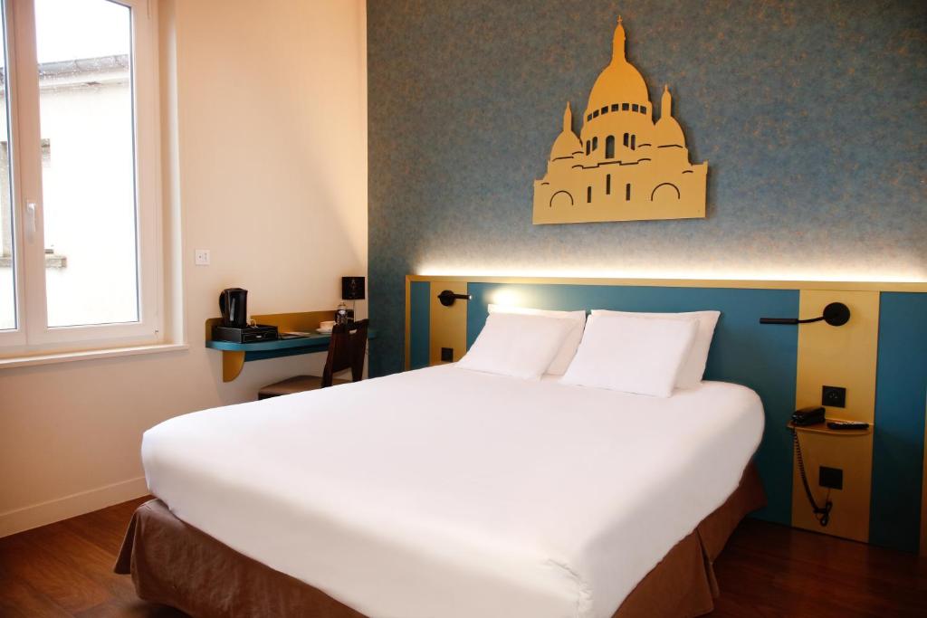 um quarto com uma grande cama branca num quarto em Hôtel de France Vire em Vire