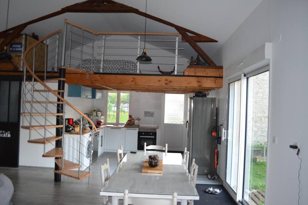 eine Küche mit einem Esstisch und einem Loft in der Unterkunft Joinville : Grange entièrement rénovée style loft. in Joinville