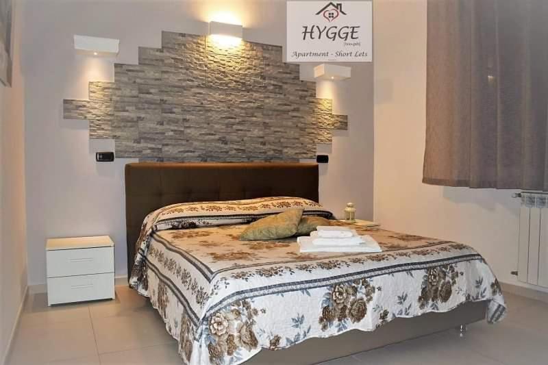 una camera con un grande letto e un muro di mattoni di HYGGE Apartment Short Lets a Taranto